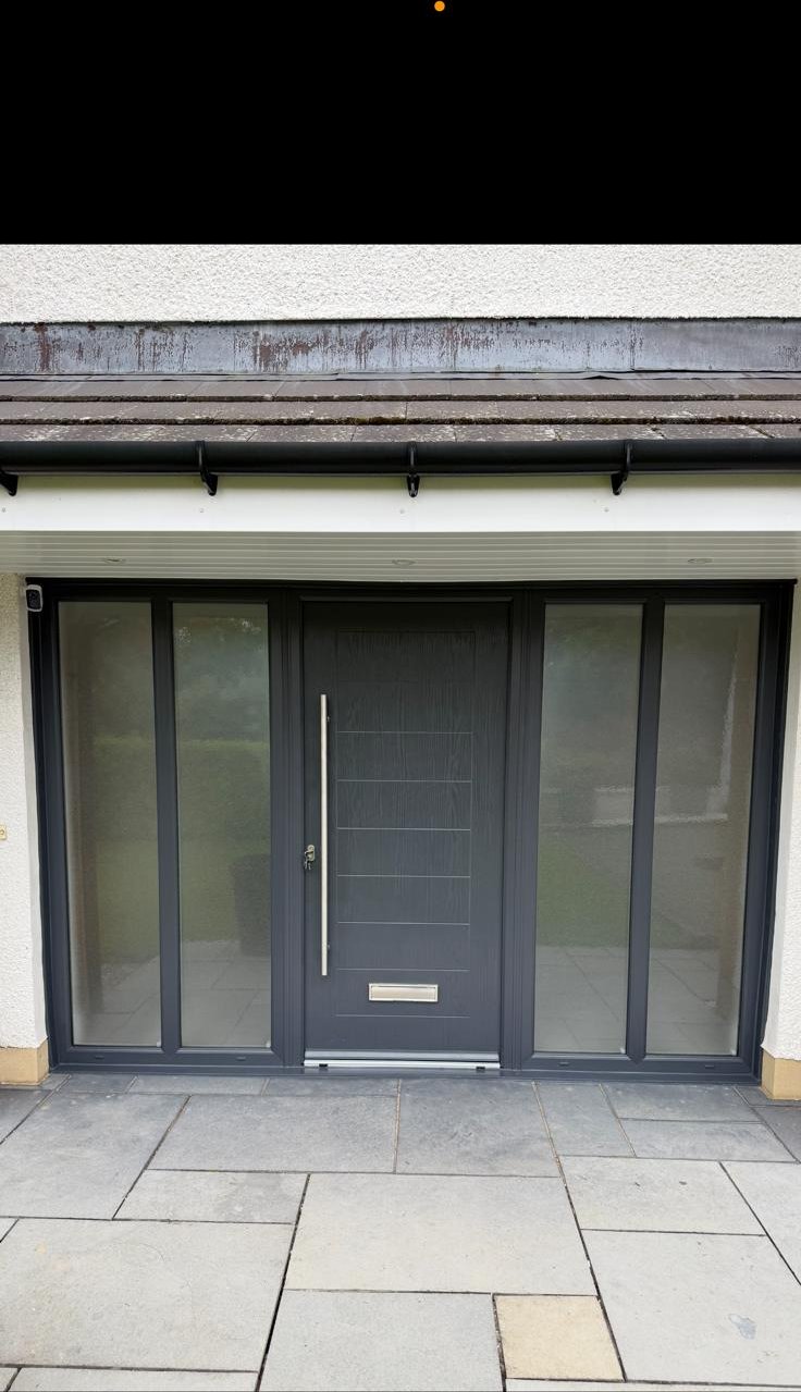 Anthracite composite front door with full-height sidelights and slate paving