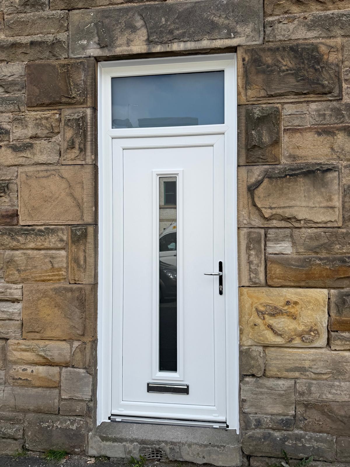 White PVC door with a top transom set in a sandstone wall