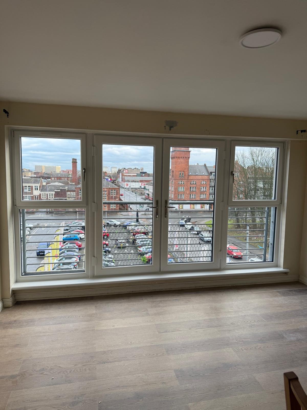 Wide four-pane window installation in an apartment with a Glasgow city view